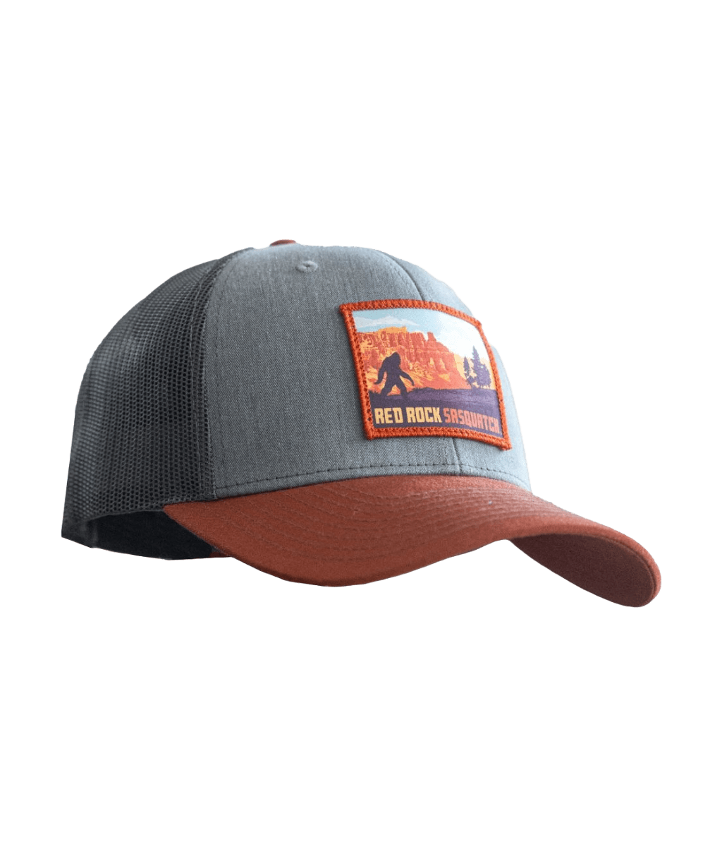 Gray and brown trucker hat with a patch featuring a Bryce Canyon and Sasquatch scene.