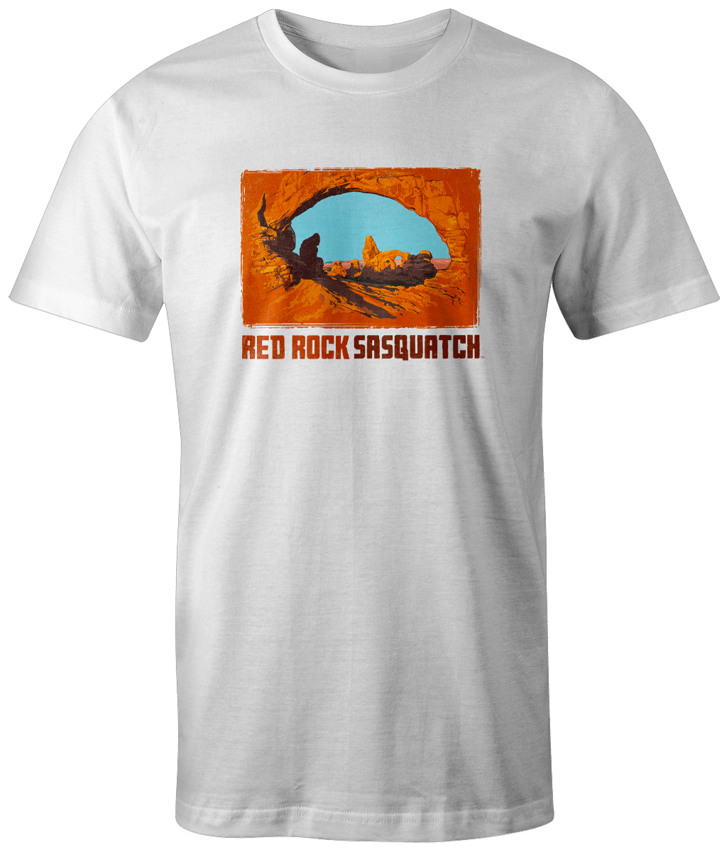 White short-sleeve t-shirt featuring a Sasquatch silhouette at Delicate Arch in Arches National Park.