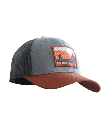 Gray and brown trucker hat with a patch featuring a Bryce Canyon and Sasquatch scene.