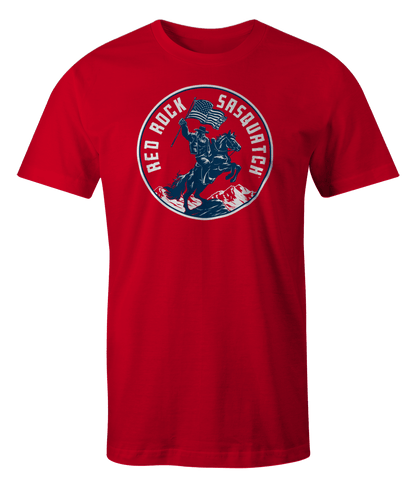 Ivory Squatchrider t-shirt with red text. Showcases Sasquatch on horseback with an American flag. A vintage-inspired patriotic design.