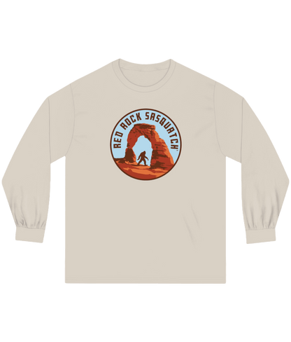 Sand-colored long-sleeve Delicate Arch tee. Displays a unique graphic of Sasquatch at Delicate Arch.