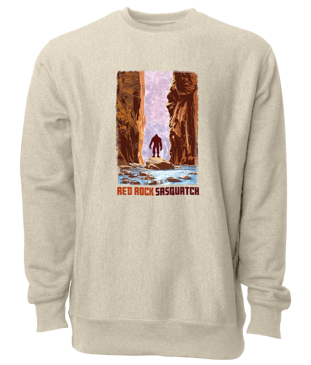 This sand-colored crewneck sweatshirt showcases a Sasquatch wading through The Narrows in Zion National Park. Ideal for outdoor adventures and casual wear.